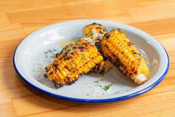 Close up grilled corn on the cob in white plate
