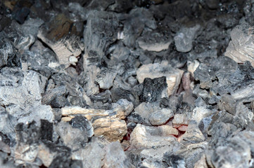 A pile of burnt coal with bokeh effect. The coal has been used in the blacksmith forge.