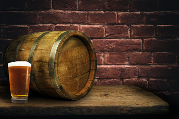 Wooden barrel and glass of beer on a old oak table of wood.