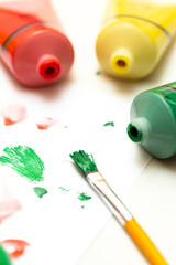 Brush with green acrylic color and many acrylic color tube