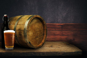 Wooden barrel and glass of beer on a old oak table of wood.