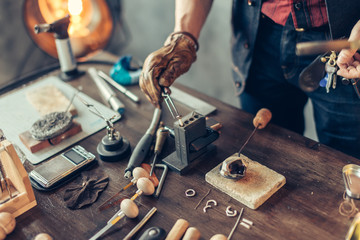 man putting heated metal on the table, close up cropped photo.
