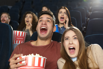 Young couple screaming watching horror movies at the local cinema