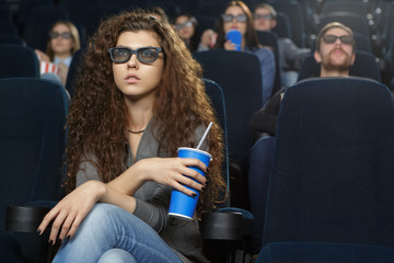 Young woman watching a 3D movie in an empty movie theatre