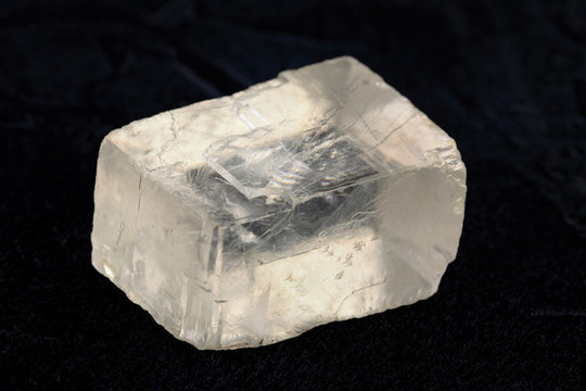 Raw Iceland spar from Krasnoyarsk region, Russia on black cement background.