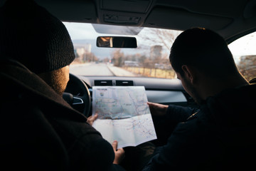Two Robbers looking at a map and planning their next robbers,one of them is holding a gun.
