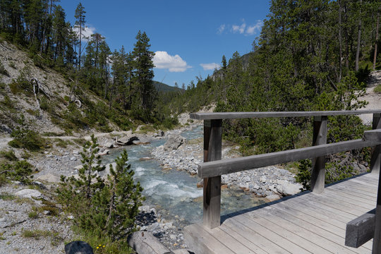 Bergbach mit Holzbr&uuml;cke im Vordergrund