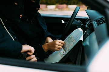 bank robbers putting their mask on prepared to do their next robbery,checking and loading their...