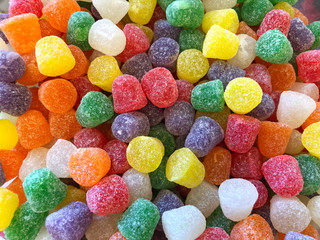 top view flat lay background bright red, yellow and yellow Natural Fruit gum drops coated in...