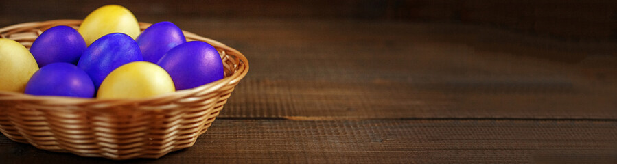 Yellow and purple Easter eggs in the basket. The concept of a ho