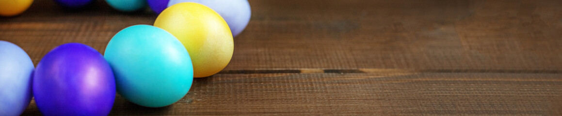 Wooden background with colored Easter eggs. Concept and happy Ea