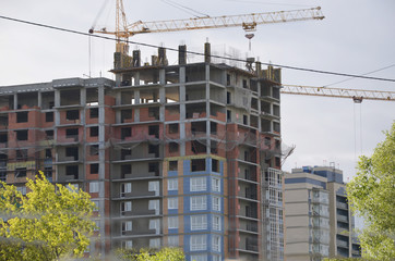 Building site background. Construction site with crane and building. Construction crane near the building. near old houses