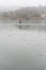 Winter SUP ride on icy lake