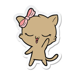 sticker of a cartoon cat with bow on head waving