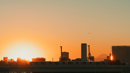 Obraz premium Tokyo beautiful twilight sunset scene. Silhouette view of city, train, industry, and Fuji mountain, copy space on clear sky. Cityscape and nature, Japan lifestyle, or Asia travel destination concept