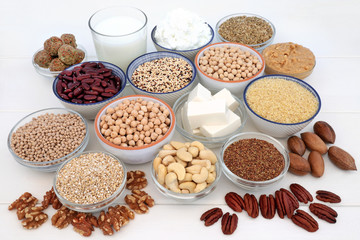 Vegan health food selection with bean curd, legumes, nuts, seeds, quinoa vegetable balls, cereals, almond milk, butter and yoghurt. Super foods high in antioxidants, dietary fibre, omega 3 & vitamins.