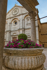 Old well in the main square of Pienza. The travertine well of the Rossellino and the Duomo Santa Maria Assunta in Pienza, Tuscany, Italy