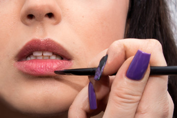make-up artist to paint girl lips brush