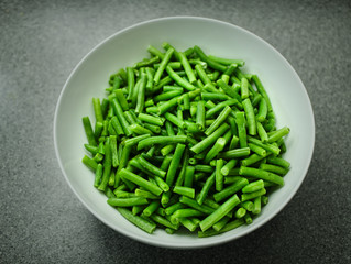 Green beans in a white bowl top view.