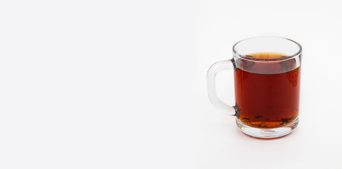 Delicious black tea in a transparent mug on a white background.Horizontal photo