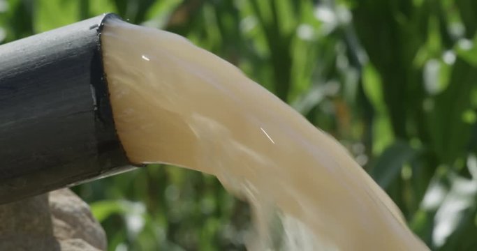 Dirty polluted water bursting out of an outdoor pipe