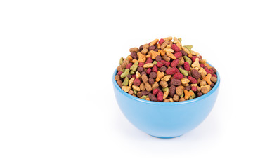 Blue bowl with cat food on white background. Color dry cat food. Copy space