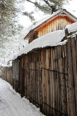 Snowing on a wooden fence