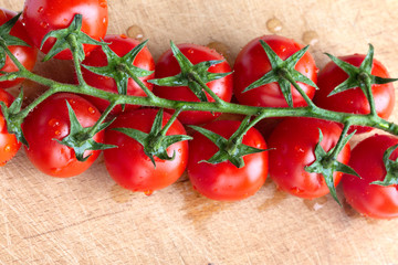 ripe cherry tomato branch on a board top