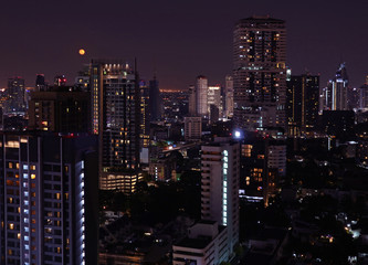 Fototapeta na wymiar Skyscrapers view of Bangkok downtown on the bright full moon night 