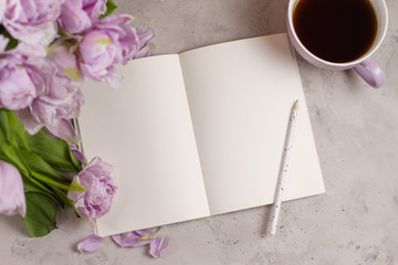 Romantic flat lay composition mock up sketch pad or notebook with violet double tulips flowers and cup of coffe or tea. Place for text