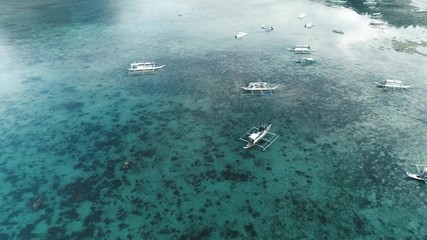 Aerial drone view of boats anchored in the bay with clear and turquoise water. Boat and yacht in the tropical lagoon. Tropical landscape. El Nido, Palawan island, Philippines.