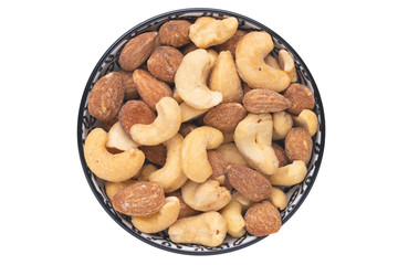 Nuts background. Close-up of roasted and salted almonds and cashew nuts in a ceramic bowl isolated on a white background. Gourmet nut mix with almonds. Macro. Top view.
