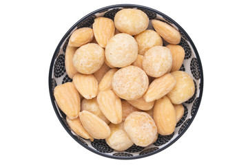 Nuts background. Close-up of roasted and salted macadamias and almonds nuts in ceramic bowl isolated on a white background. Gourmet nut mix with macadamias. Macro. Top view.