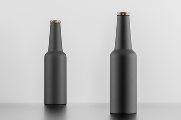Two matt black bottles over white background