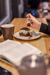 Delicious chocolate cake in white plate on wooden table background, closeup. selective focus, noise effect