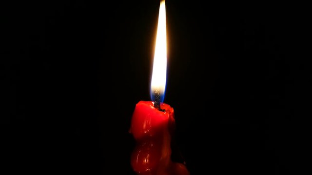 Vela roja encendida sobre fondo negro