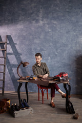 boss craftsman controlling the work of shoemakers, full length photo