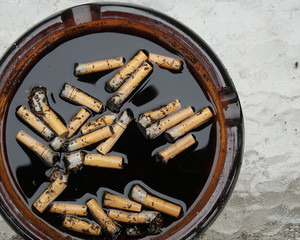 Cigarette butts in dirty ashtray
