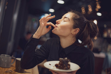 Picture of cheerful girl in cafe, eating piece of cake, selective focus, noise effect