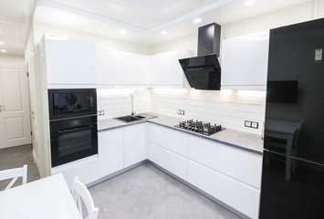 modern white kitchen interior with   LED backlight. Household appliances oven, gas stove, hood.