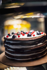 A view of a very appetizing and bright cake which is found in a confectioner's refrigerator-showcase in a cafe. selective focus, noise effect