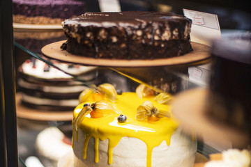 A view of a very appetizing and bright cake which is found in a confectioner's refrigerator-showcase in a cafe. selective focus, noise effect
