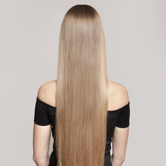 Portrait Of A Beautiful Young Blond Woman With Long Straight Hair. Back View