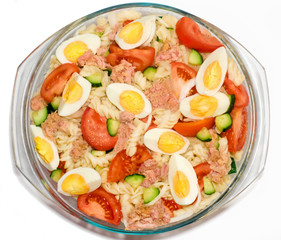 Tuna salad isolated on white background. Top view. Tuna, pasta, eggs,   cucumbers, tomatoes, onions. Traditional salad.