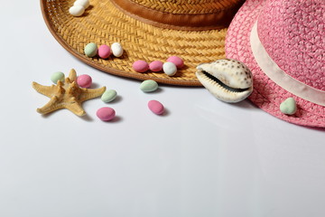 Accessories for summer holidays. Sun hats, seashells colored pebbles and starfish on a white background.