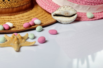 Accessories for summer holidays. Sun hats, seashells colored pebbles and starfish on a white background.