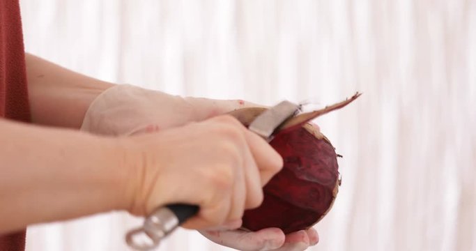 Cooking at home, Woman peeling beetroot using hand peeler, close-up, staedicam