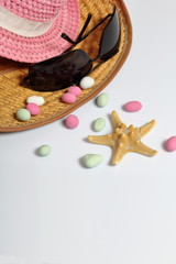 Accessories for summer holidays. Sun hats, sunglasses, colored pebbles and starfish on a white background.