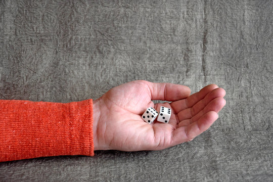  White dices on the male palm, close up. Board games.