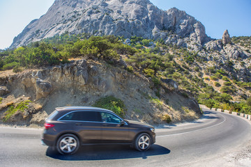 Naklejka premium SUV Moves along a winding road in the mountains